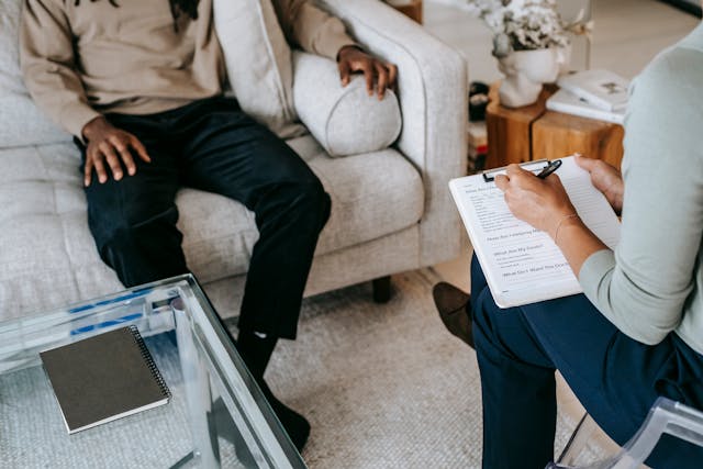Person receiving therapy, talking to a therapist in a professional setting