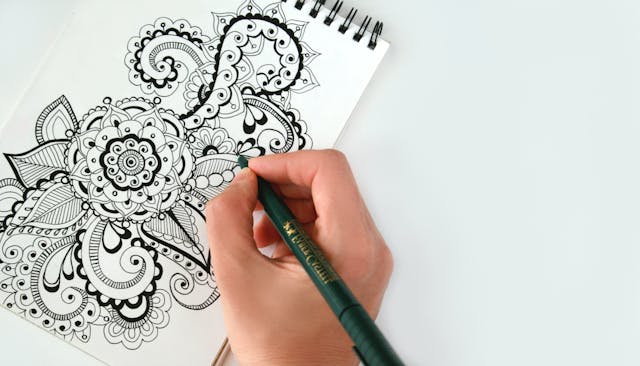 Person drawing on paper, expressing creativity
