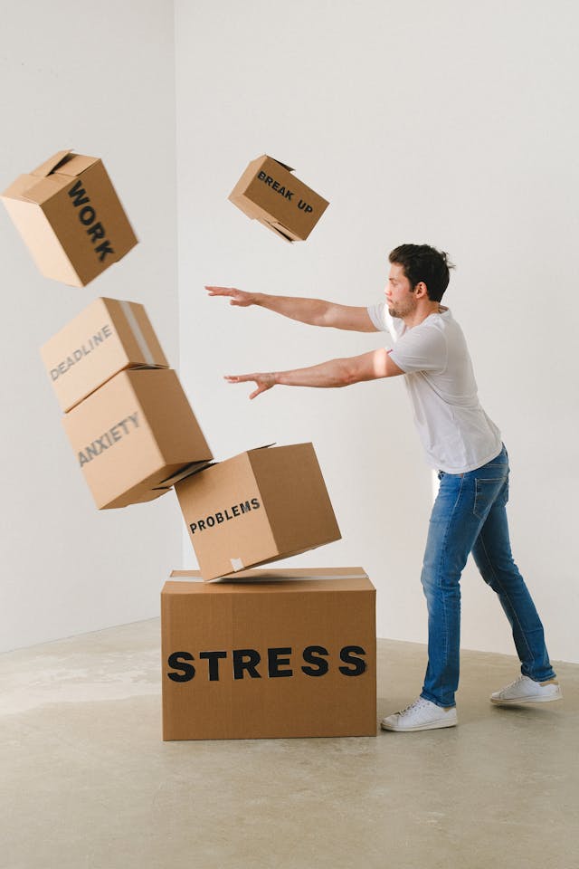 Man knocking over stacked boxes labeled with mental health conditions such as depression and anxiety
