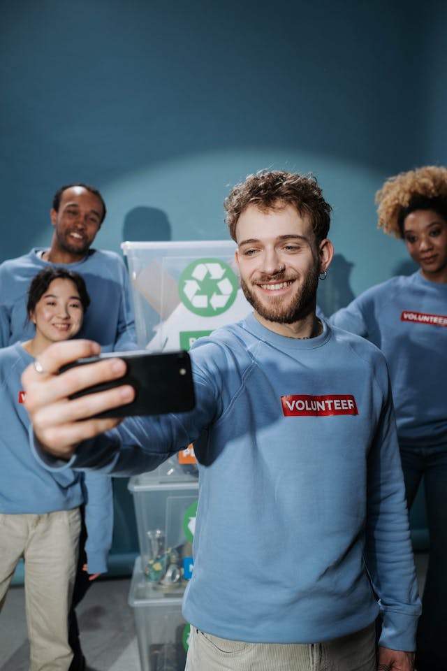 Four people wearing shirts labeled volunteer, standing together and smiling