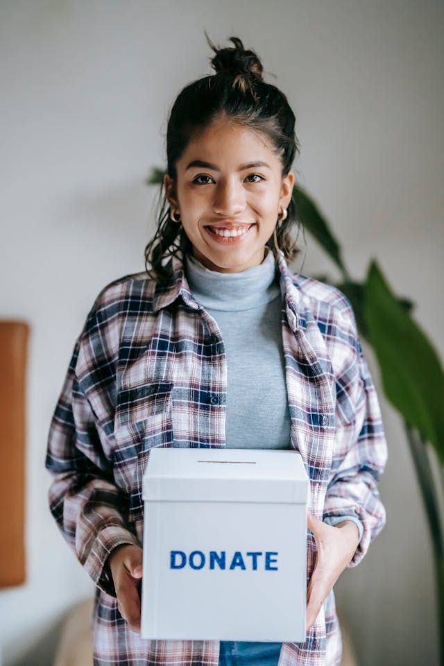 Woman holding a donation box labeled donate